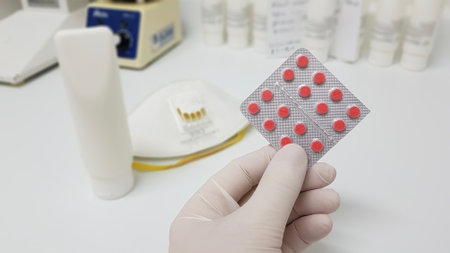 A selective focus closeup of a hand holding a pad of medicine tablet- concept Coronavirus prevention and treatmentの写真素材