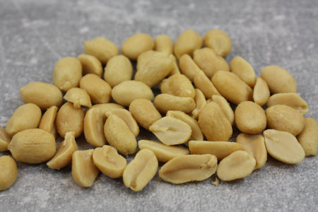 A closeup shot of roasted salted peanuts on a blurred background
