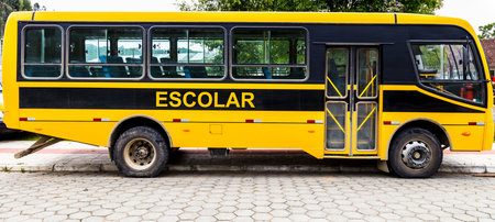 A yellow school bus parked on pavement street in Brazilの写真素材