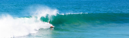 A surfer surfing on crazy sea waves on a sunny day
