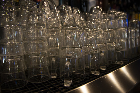 A closeup shot of many glasses stacked at the barの写真素材