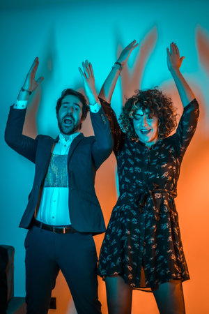 A vertical shot of a male and a female dancing macarena