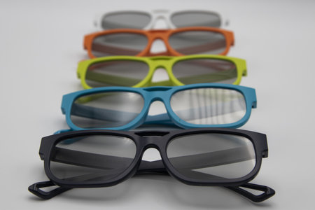 A set of colorful sunglasses on a light-colored backgroundの写真素材