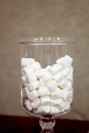 A vertical shot of a glass jar filled with mini marshmallowsの写真素材