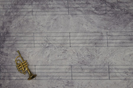 A music sheet background with a miniature trumpetの写真素材
