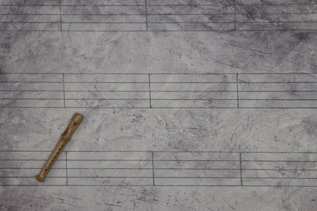 A music sheet background with a miniature wind instrumentの写真素材