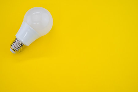 A closeup shot of a LED light bulb isolated on a yellow background