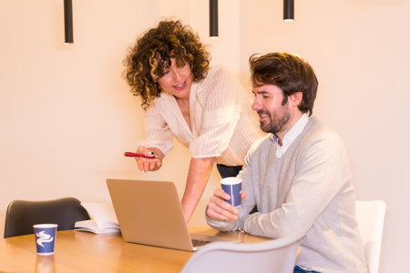 A male and a female discussing a project around a round table at the officeの写真素材