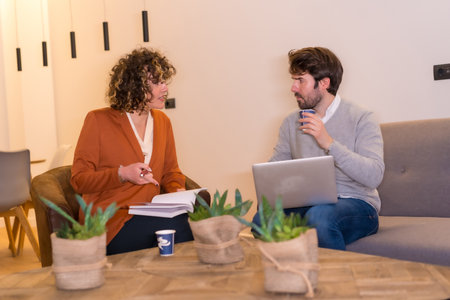 A male and a female discussing a project in front of a table at the officeの写真素材