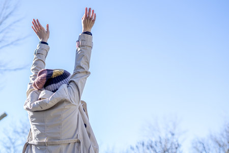 A back view of a young happy female with her arms in the airの写真素材