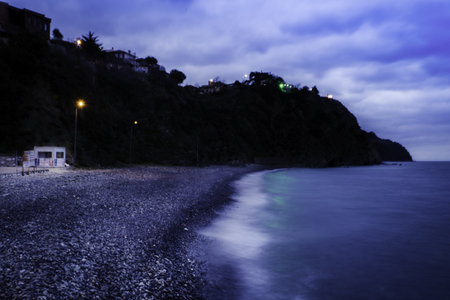 A rocky shore washed by ocean waves in the eveningの写真素材