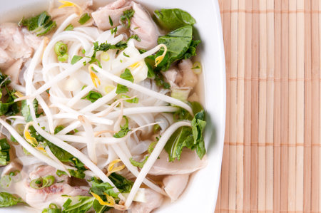 Vietnamese pho soup with chicken, broth, bean sprouts, noodles, and basil