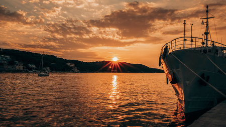 A mesmerizing scenery of a ship on the sea at sunsetの写真素材