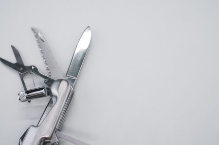 A high angle shot of a swiss army knife on a grey surface