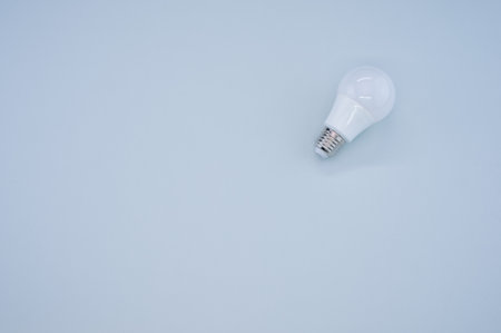 A high angle shot of a lightbulb on a blue surfaceの写真素材