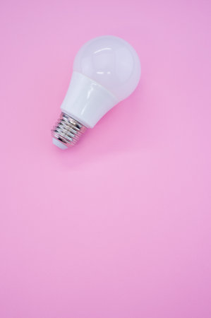 A vertical high angle shot of a lightbulb on a pink surfaceの写真素材