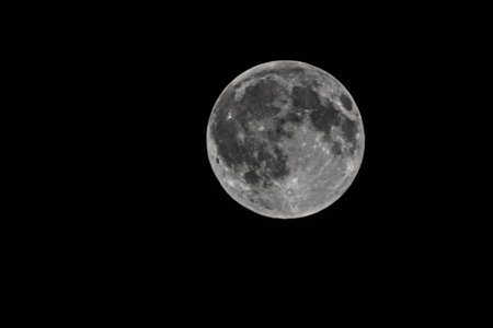A closeup of the full moon against a clear, blackの写真素材