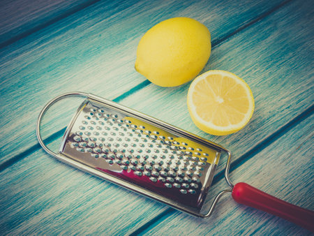 A closeup shot of fresh lemons and grater on a wooden surfaceの写真素材