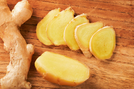 A closeup shot of sliced ginger on a chopping board