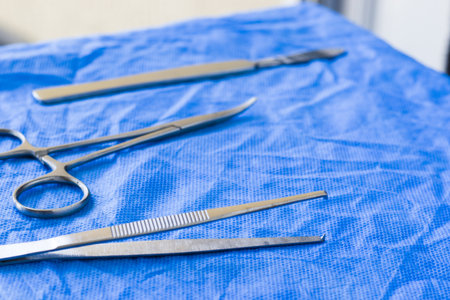 A closeup of dissection kit tools on blue surgical clothの写真素材