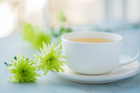 A closeup shot of a cup of tea and flowersの写真素材