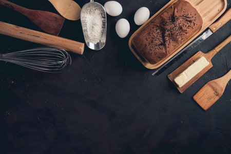 A top view of bakery utensils and ingredients on a black tableの写真素材