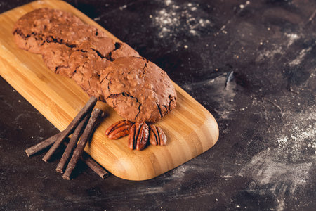 A closeup shot of chocolate and walnut cookies on a black tableの写真素材