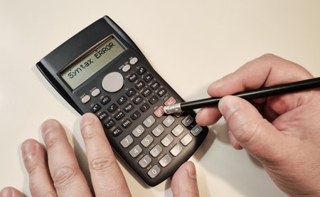 A man computing on black scientific calculator with sntax error text on screen