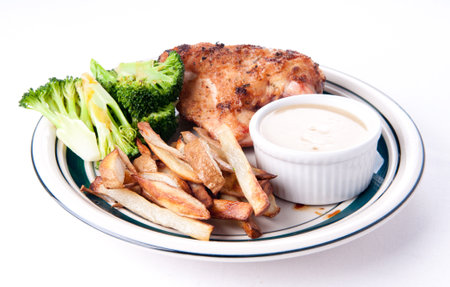 crispy skinned roast chicken breast with dipping sauce, hand cut french friesの写真素材
