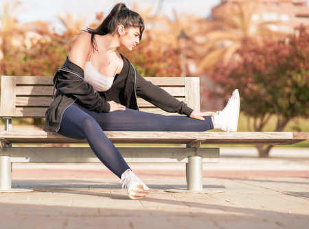 A shallow focus shot of a young Caucasian female during her workout in the parkの写真素材