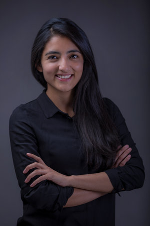 A vertical shot of a Mexican businesswoman smiling with her hands crossed