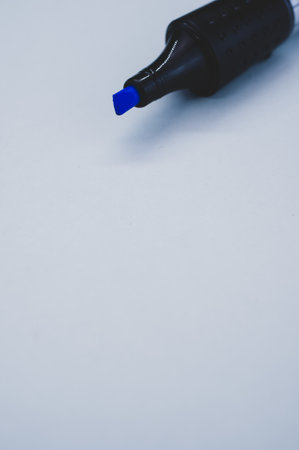 A vertical shot of a broad blue marker without a cap isolated on a gray backgroundの写真素材
