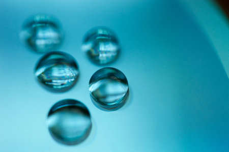 A macro shot of water drops on a blue compact disc