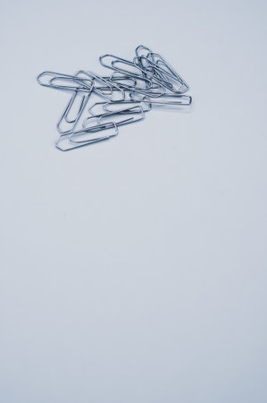 A vertical shot of a pile of paper clips isolated on a gray backgroundの写真素材