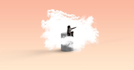 A child sitting on a cylinder and pointing surrounded by a cloud-dream, imagination conceptの写真素材