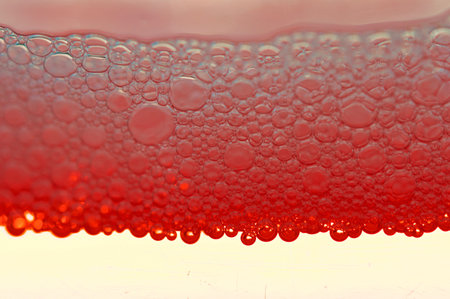 A macro shot of soap bubbles on red backgroundの写真素材