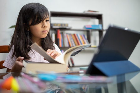 A pretty Hispanic schoolgirl studying online at home - home schooling, online educationの写真素材