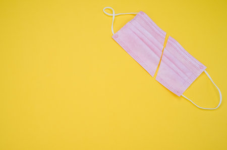 A top view of a facemask cut in half isolated on a yellow background - COVID-19の写真素材