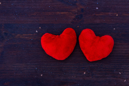 Two red hearts lie on a wooden surface, valentine's dayの写真素材
