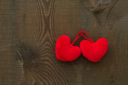 Two red hearts lie on a wooden surface, valentine's dayの写真素材
