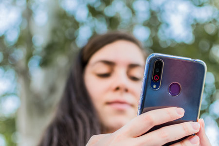 A low angle shot of a young female checking her cellphone