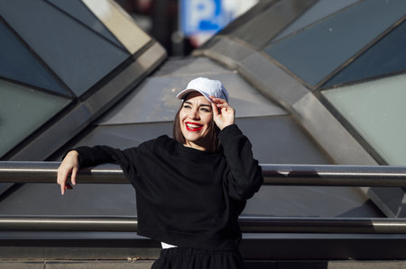 A Caucasian woman with red lipstick and a cap