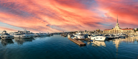 A panorama shot of the harbor in Sochi, Russia under the cloudy sky in pink shadesの写真素材
