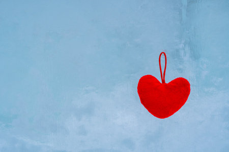 Red heart made of fabric lies on a blue icy surface, valentine's dayの写真素材