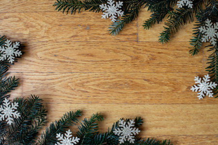 A top view of Christmas ornaments with snowflakes on a wooden surface with space for textの写真素材
