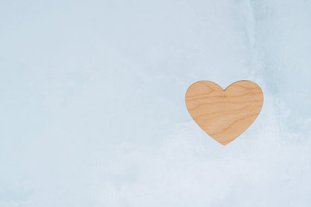 Wooden light heart, a sign of love, lies on a blue ice background, valentine's dayの写真素材