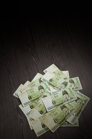 A vertical shot of South Korean won, on a wooden surface