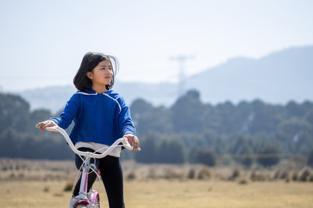 A Mexican girl on a bicycle outdoors during the daytimeの写真素材
