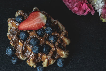 A closeup shot of homemade Belgian waffles with strawberries and blueberriesの写真素材