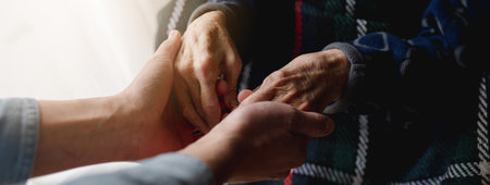 A caring grandson holding grandmother's handsの写真素材